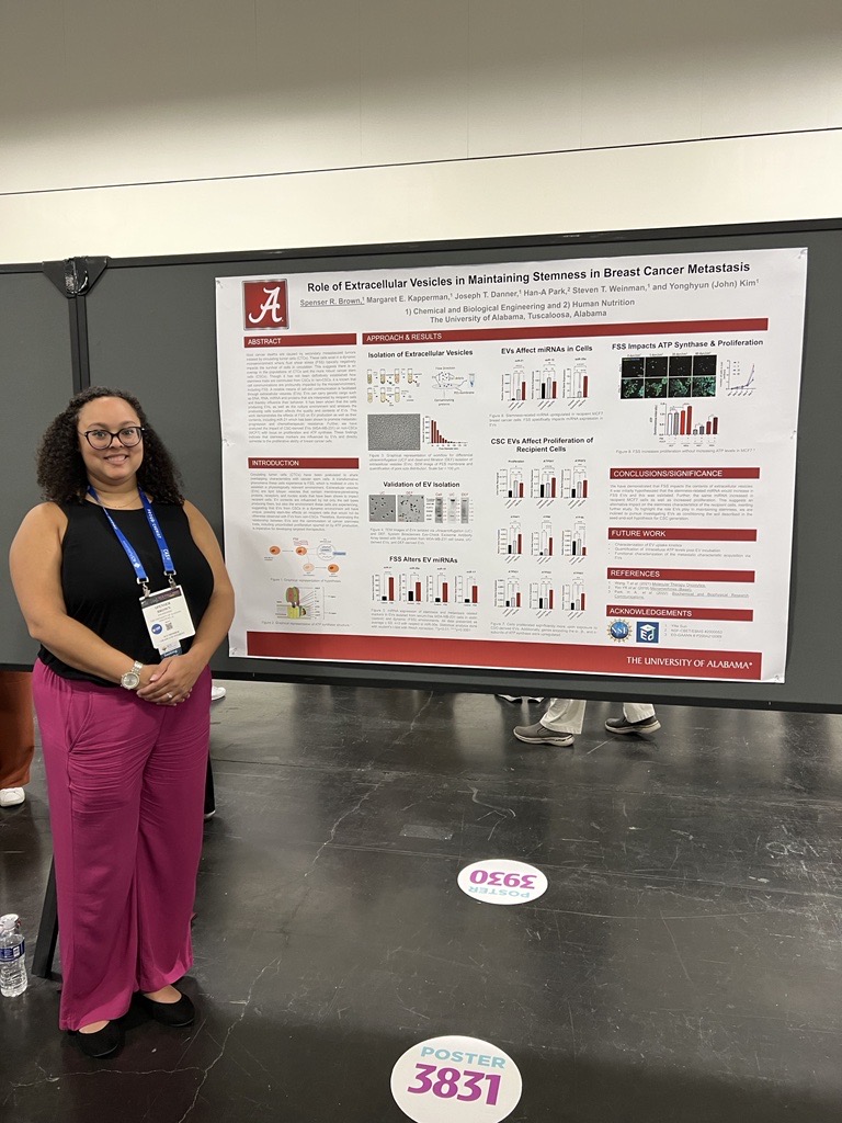 Female graduate student standing in front of her research poster