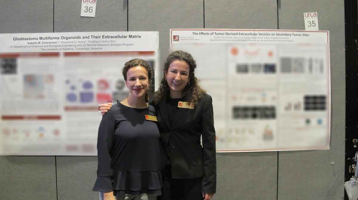 Two female students standing in front of blurred posters