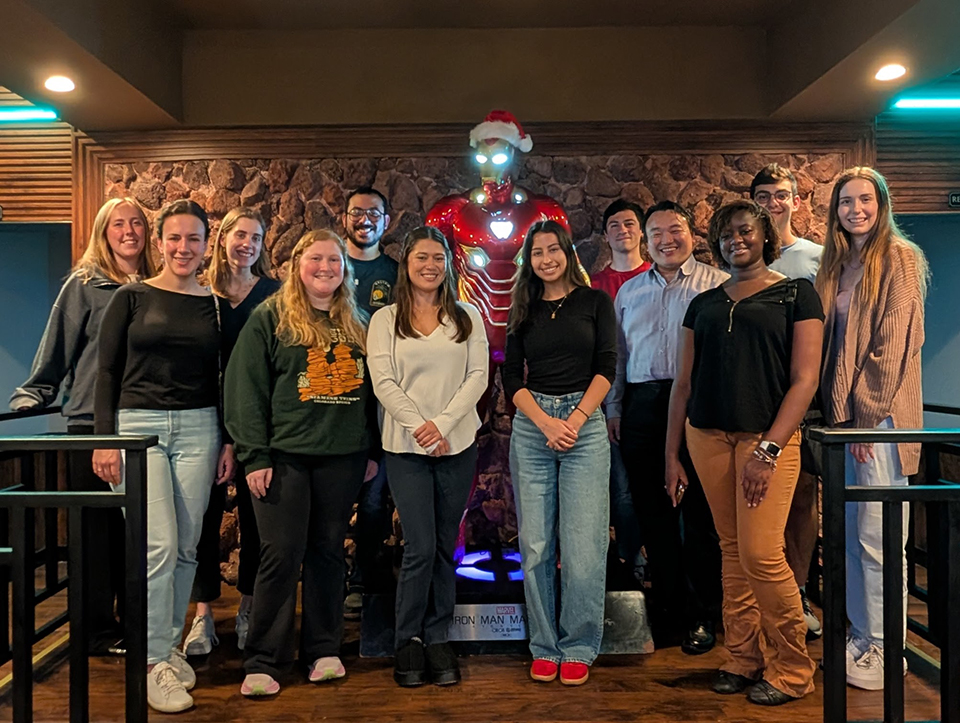 Group photo of people in front of Iron Man